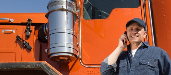 truck driver on phone next to truck